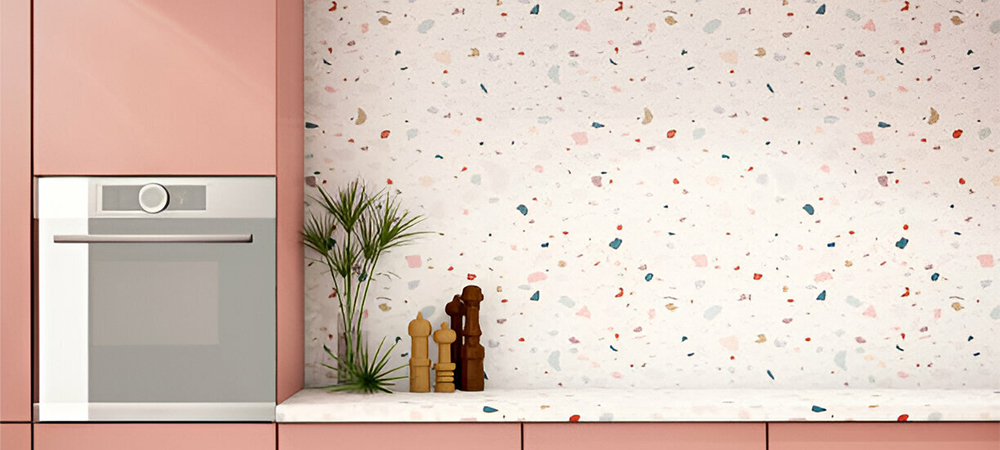 Pink kitchen cabinets with a colorful terrazzo tile backsplash, adding a modern and stylish touch